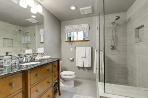 A remodeled residential bathroom with gray walls.