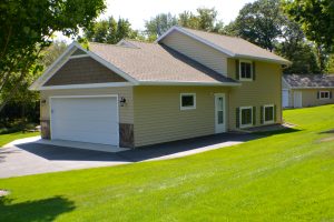 A modern home with a new asphalt shingle roof and a freshly mowed lawn.