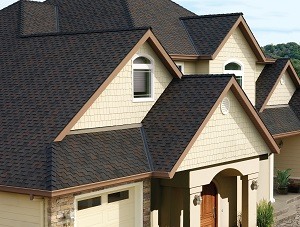 The asphalt shingle roof of a large residential home.