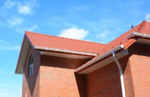 Luxury home roofing build with tiles and roof gutters