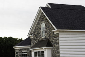 edge of roof shingles on top of the house dark asphalt tiles on the roof background color