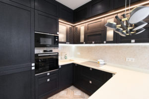 A remodeled residential kitchen with black cabinets.