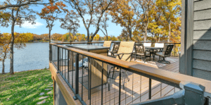 A large residential deck overlooking a lake.