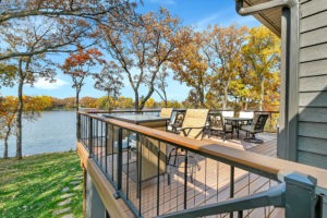 Large wrap-around deck on a home overlooking a lake.