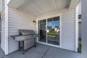 Exterior of a house with a sliding glass door and a new gas grill